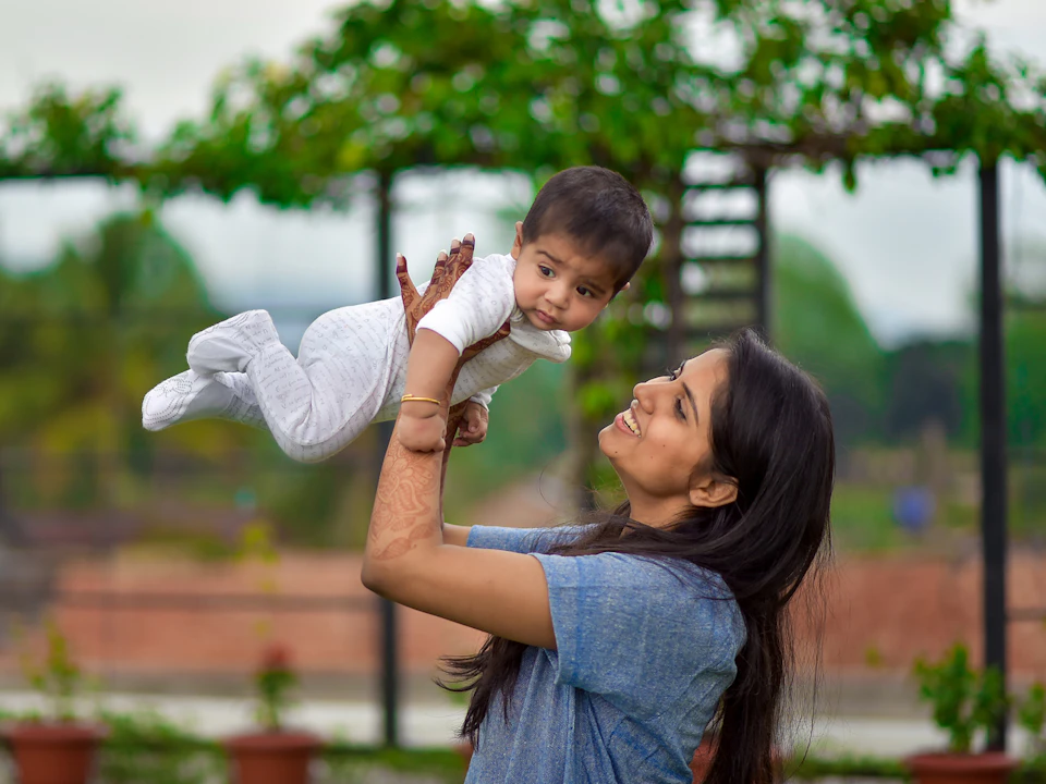 Smart young babysitter happily playing with baby